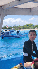 Tourists snorkel in turquoise Indonesian waters near sandy beach