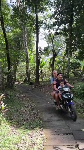 Late-night moped journey through forest path in Indonesia