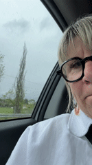 Woman displays melancholy expression during rainy car journey in France