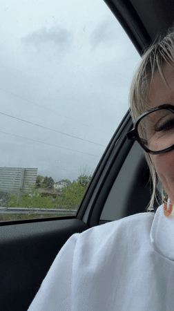 Woman displays melancholy expression during rainy car journey in France