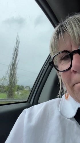 Woman displays melancholy expression during rainy car journey in France