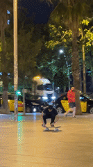 Skateboarder performs trick on Barcelona walkway at night