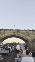Tourist activity documented around Prague's Charles Bridge during evening hours