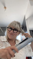 Woman styling hair, making playful faces in Chambœuf bathroom