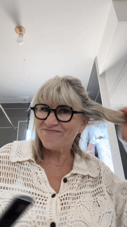 Woman styling hair, making playful faces in Chambœuf bathroom