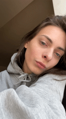 Woman in grey hoodie recorded smirking at camera in Krasnoyarsk