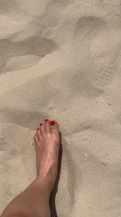 Person with red nail polish walks on Tel Aviv beach