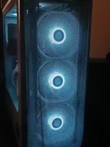 The video shows the inside of a white computer case. The case has a glass side, and the front panel has three round fans with blue light. The computer has a CPU cooler with a fan, white RAM sticks with RGB lighting, and a Radeon graphics card. The graphics card is supported by a white stand. The inside of the case is lit with white light. The temperature on the CPU cooler reads 51 degrees.