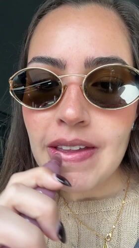 Woman applies lip gloss in car on Mexico street