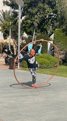 Street performer practices aerial hoop tricks in Alanya park