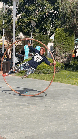 Street performer practices aerial hoop tricks in Alanya park