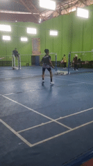 Badminton match in progress at an indoor Samarinda court