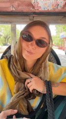 Woman in headscarf rides tuk-tuk on tree-lined Vrindavan street