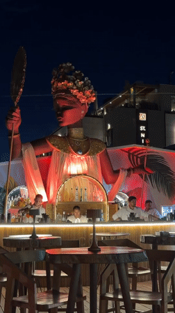 Rooftop bar night in Himarë, Albania, statue and cocktails