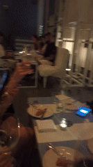 Women share wine and pizza at restaurant in Bali