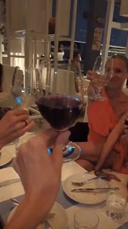 Women share wine and pizza at restaurant in Bali