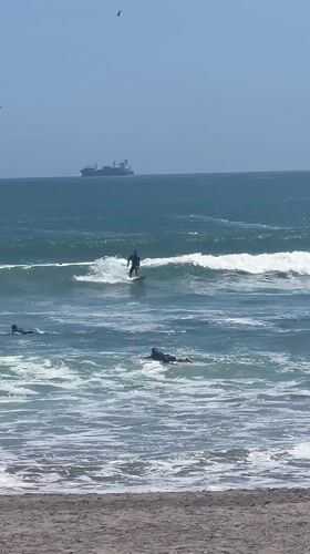 Three surfers enjoy waves near Arica, Chile