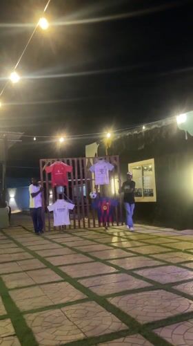 Evening patrons gather at illuminated Nigerian bar patio