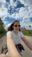 Woman films bicycle selfie on rural Russian road