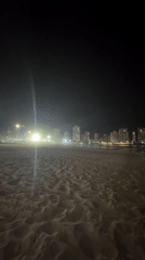 Nighttime beach scene captured with city skyline backdrop