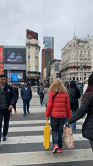 Pedestrians cross street near Buenos Aires Obelisk