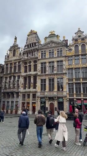 Pedestrians and horse carriages populate Brussels' Grand Place square