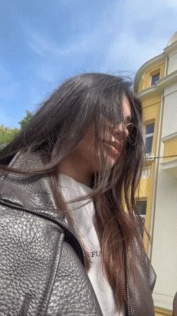 Woman with vape pen walks cobblestone sidewalk in Varna