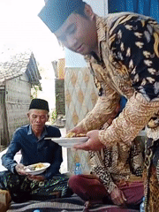 Community gathering in Dempo Barat with traditional dress and shared meals