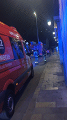 Emergency vehicles respond on a Barcelona street at night