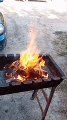 Backyard grill fire burning on a gravel lot in Chuhuiv
