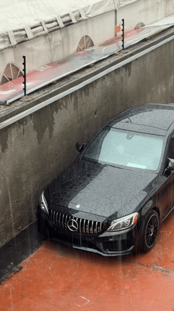 Mercedes sedan trapped between barriers during heavy rainfall in Nigeria