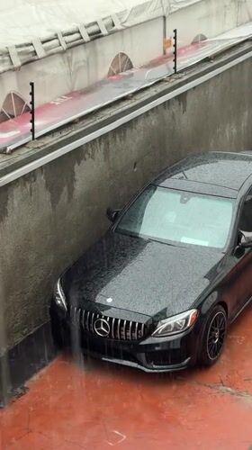 Mercedes sedan trapped between barriers during heavy rainfall in Nigeria