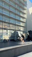 Skateboarder performs tricks near Barcelona's Torre Glòries building