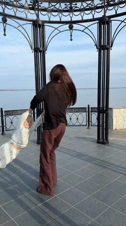 Woman and child play at Kamyshin waterfront gazebo