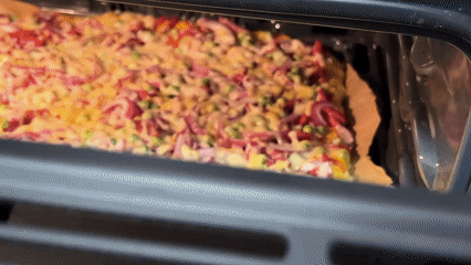 Homemade pizza with vegetables and salami bakes in Krasnodar oven