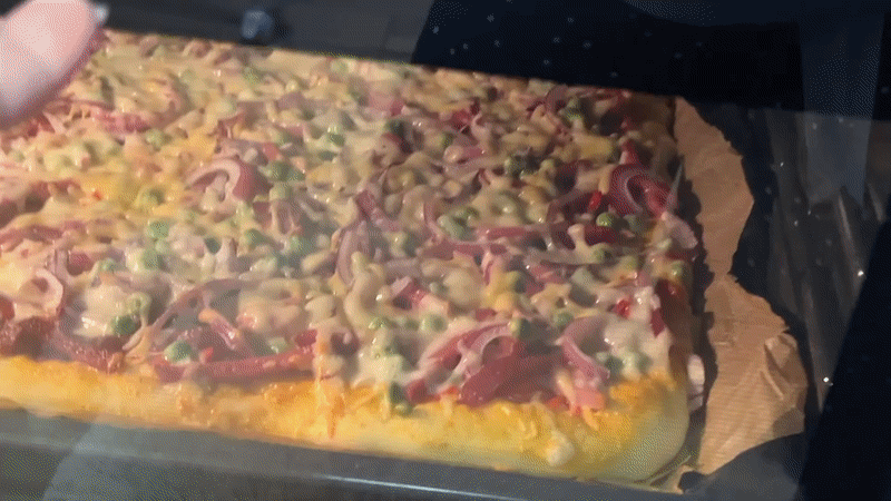 Homemade pizza with vegetables and salami bakes in Krasnodar oven