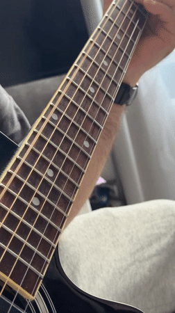Person plays acoustic guitar in Moscow apartment