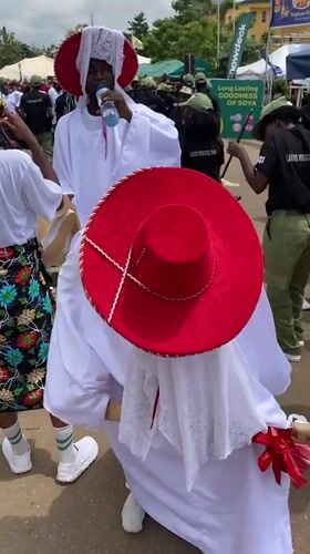 Traditional procession with robed figures and adorned horses in Alagba