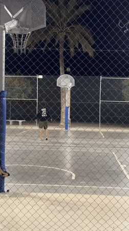 Man plays basketball at night in Altea, Spain