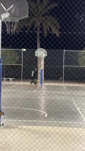 Man plays basketball at night in Altea, Spain