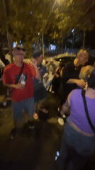 Young adults gather for nighttime street socializing in Barcelona