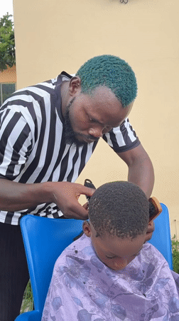Green-haired barber cuts child's hair in Ado, Nigeria