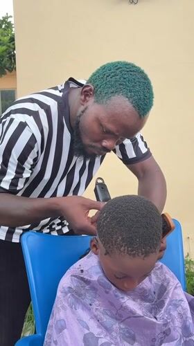 Green-haired barber cuts child's hair in Ado, Nigeria