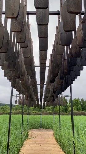 Wooden boardwalk and suspended oar installation in Russian marshland