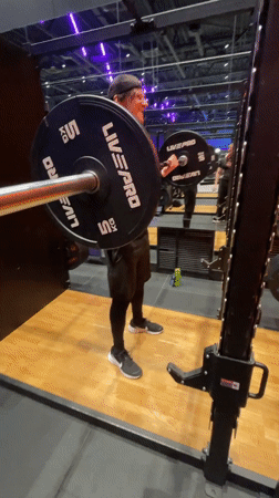 Man performs barbell curls at Murino gym