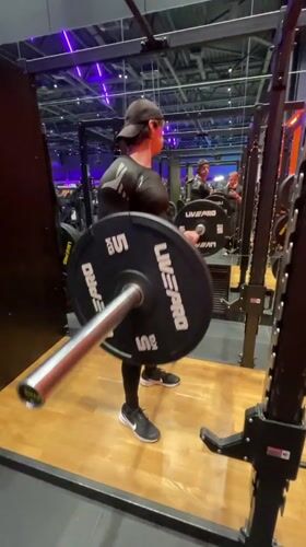 Man performs barbell curls at Murino gym