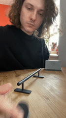 Person practices fingerboard tricks indoors in Yekaterinburg