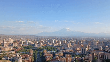 Drone footage captures urban landscape with fountain, parks, pedestrians
