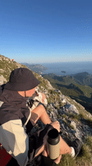 Hiker enjoys sandwich break on Montenegro mountain peak