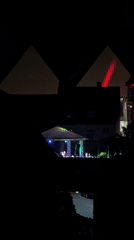 Nighttime outdoor concert near a residential neighborhood under a full moon